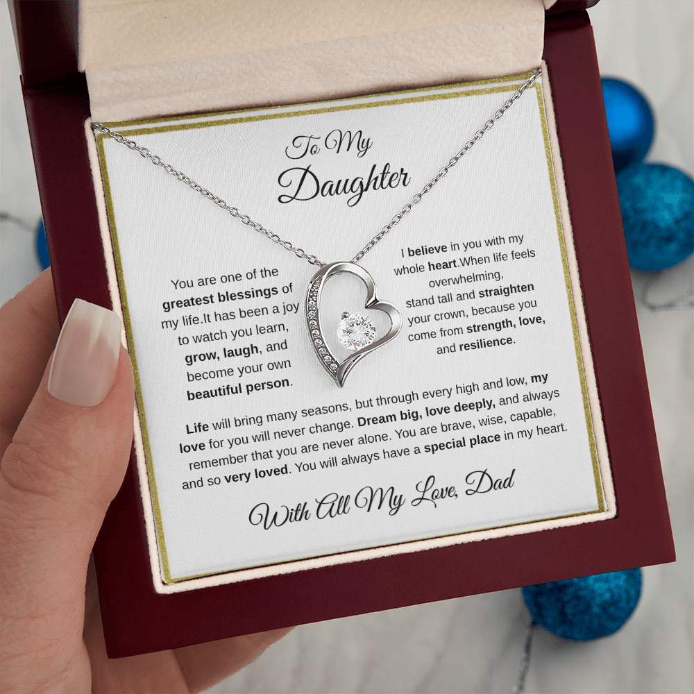 Hand holding 14k white gold-finish Forever Love Necklace in mahogany gift box