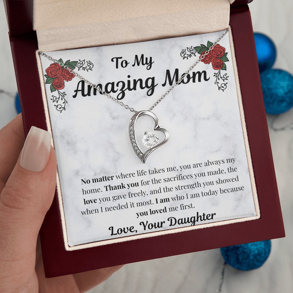 Hand holding 14k white gold-finish Forever Love Necklace in mahogany gift box