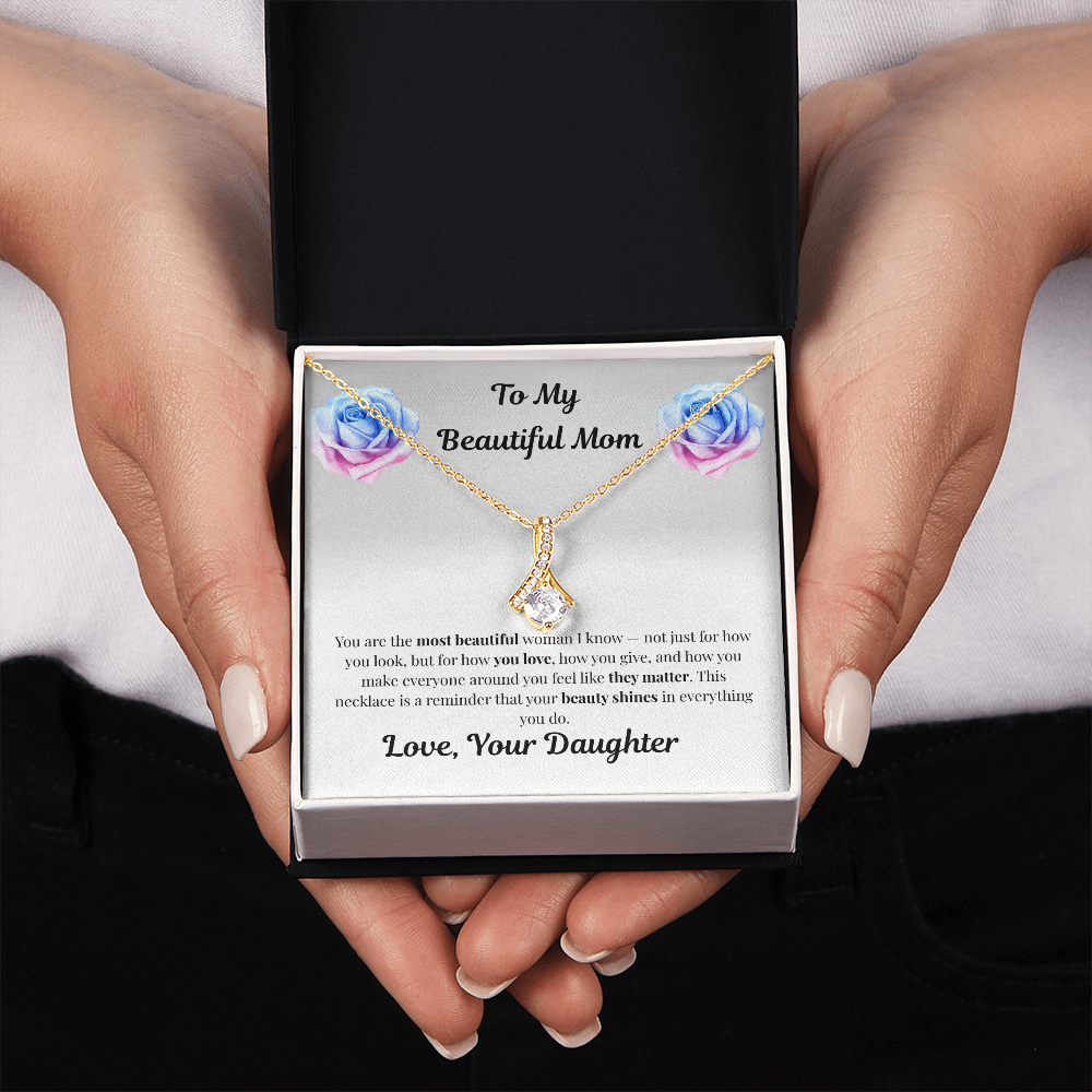 Hands holding 18K yellow gold-finish Alluring Beauty Necklace in standard gift box