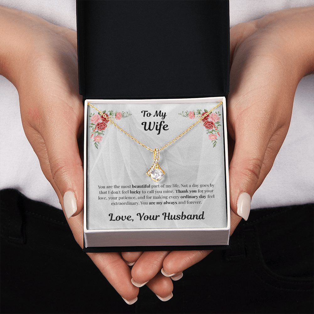 Two hands holding 18K yellow gold-finish Alluring Beauty Necklace in standard gift box