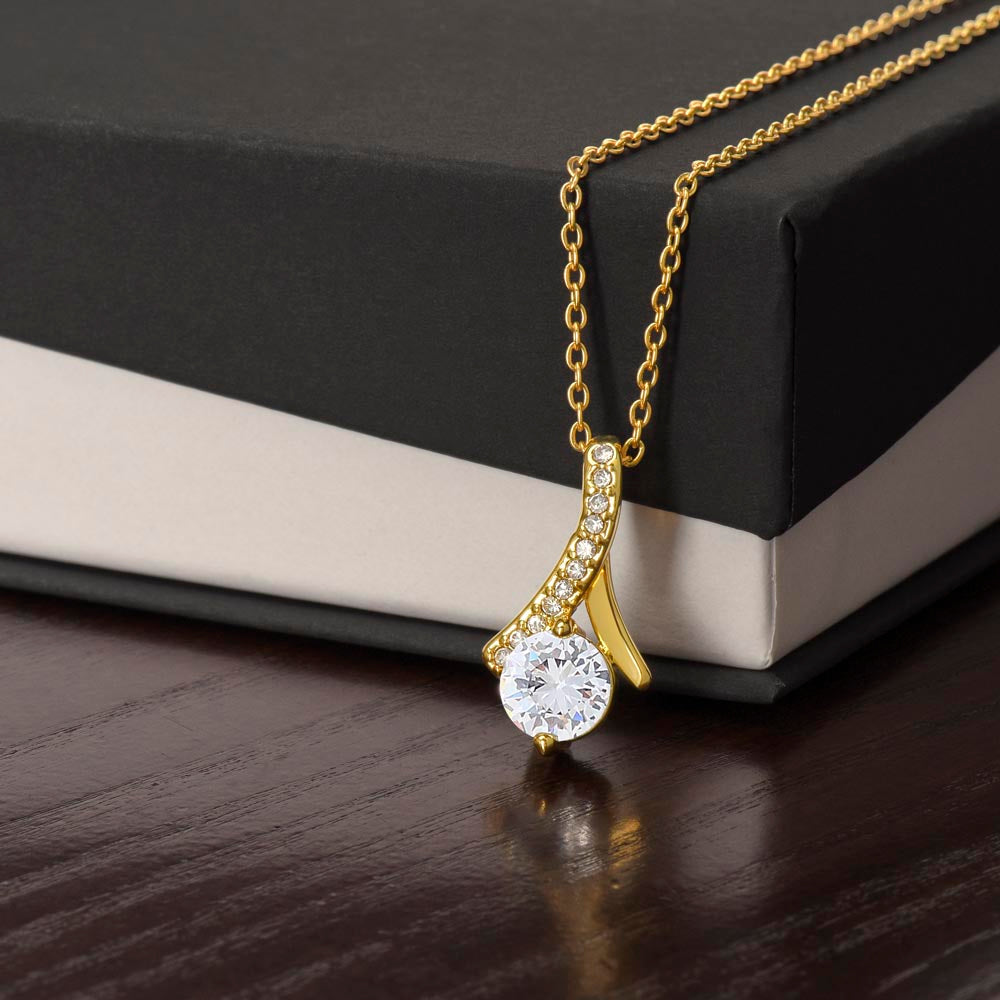 Close-up of 18K yellow gold-finish Alluring Beauty pendant beside gift box