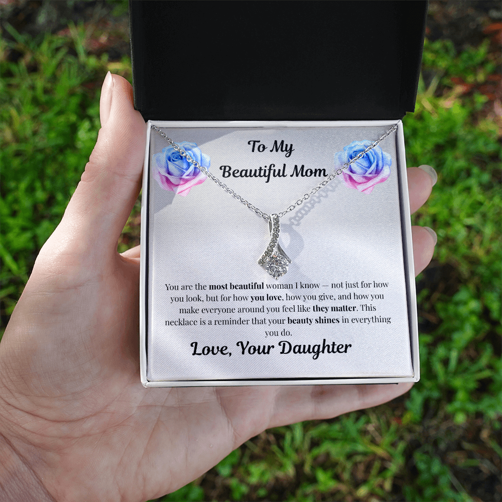 Hand holding 14k white gold-finish Alluring Beauty Necklace in standard gift box outdoors