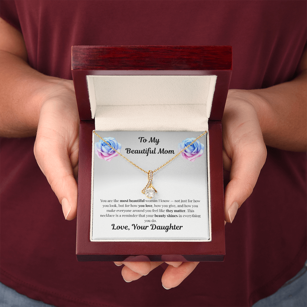 Hands holding 18K yellow gold-finish Alluring Beauty Necklace in mahogany gift box
