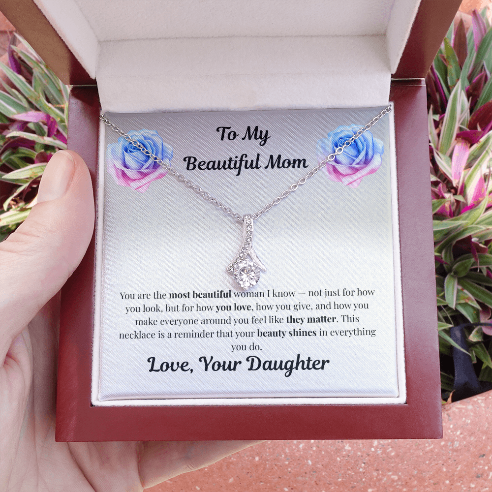 Hand holding 14k white gold-finish Alluring Beauty Necklace in mahogany gift box outdoors