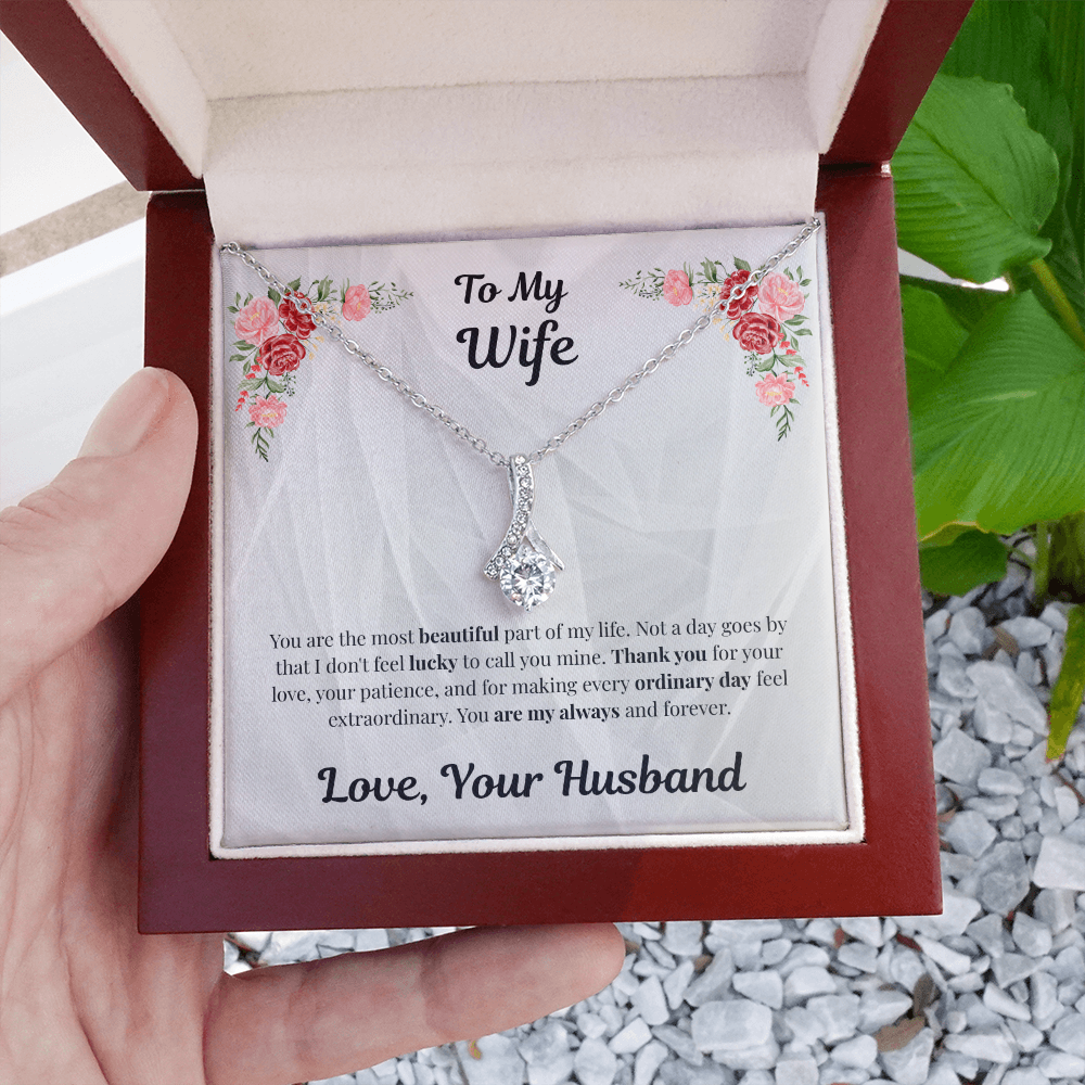 Hand holding 14k white gold-finish Alluring Beauty Necklace in mahogany gift box outdoors