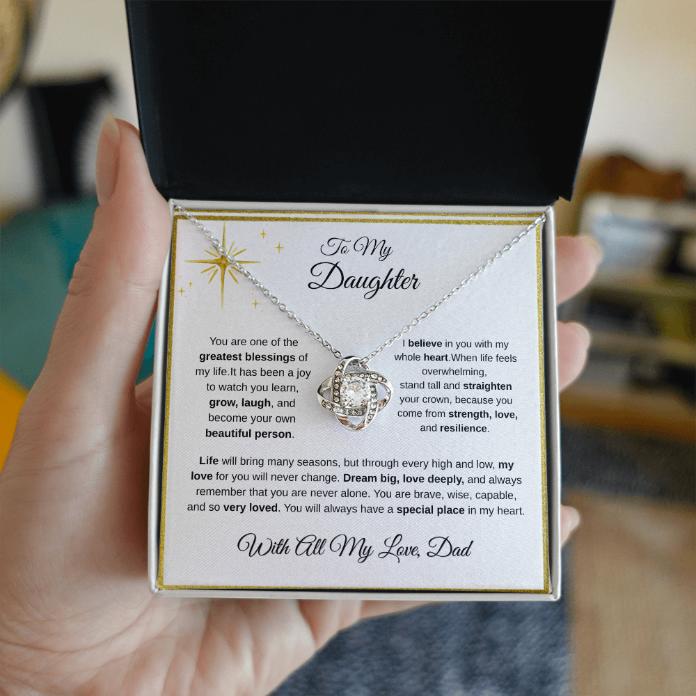 Hand holding 14K white gold-finish Love Knot Necklace in standard gift box