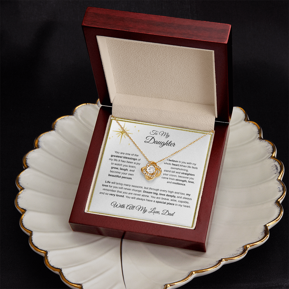 18K yellow gold-finish Love Knot Necklace in mahogany gift box on decorative plate