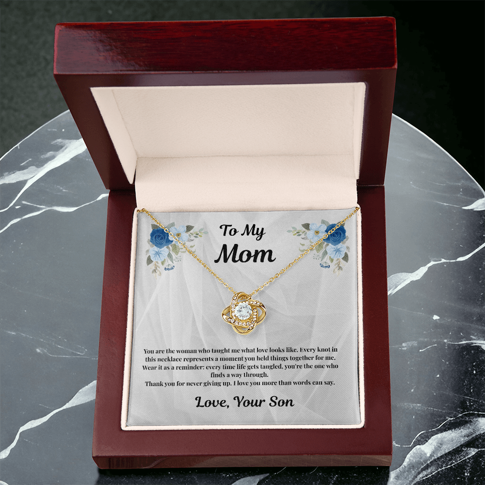 18K yellow gold-finish Love Knot Necklace in mahogany gift box on gray marble