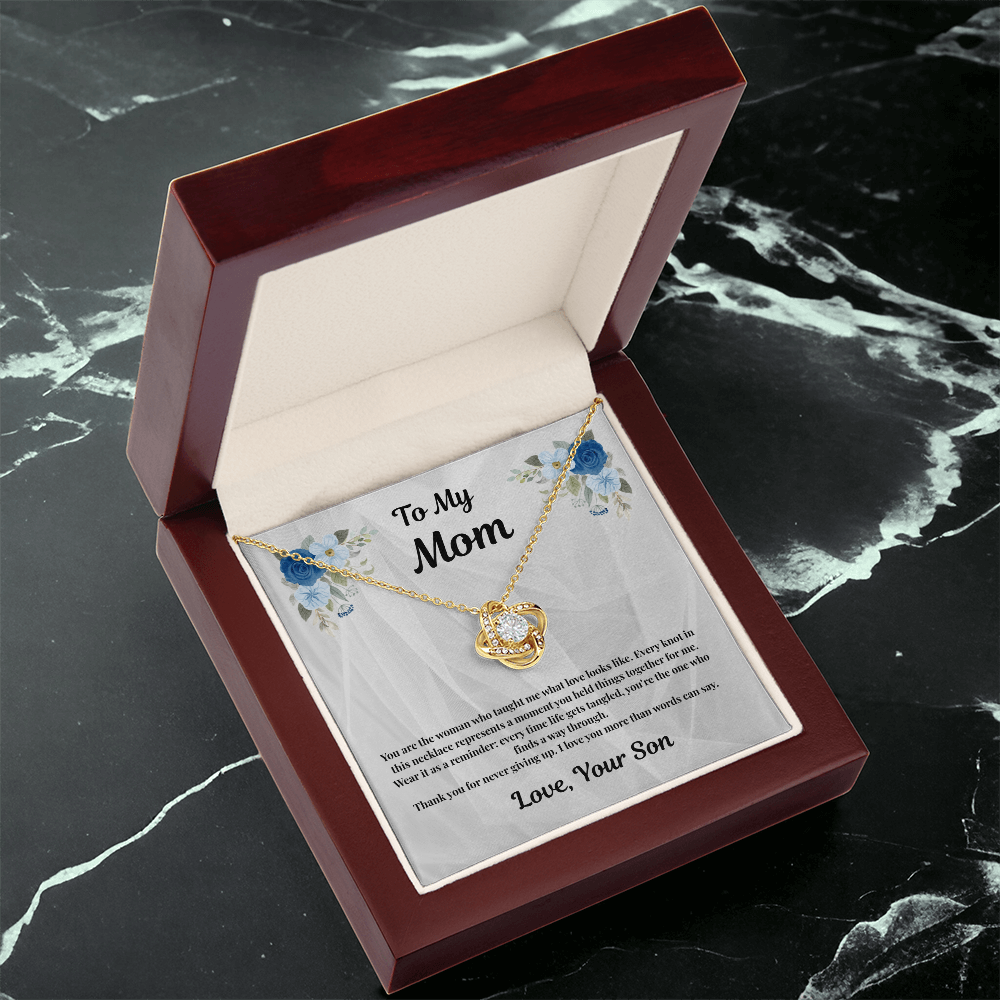 18K yellow gold-finish Love Knot Necklace in mahogany gift box on black marble