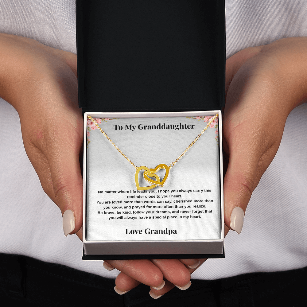 Hands holding 18k yellow gold-finish Interlocking Hearts Necklace in standard gift box with To My Granddaughter message card from Grandpa