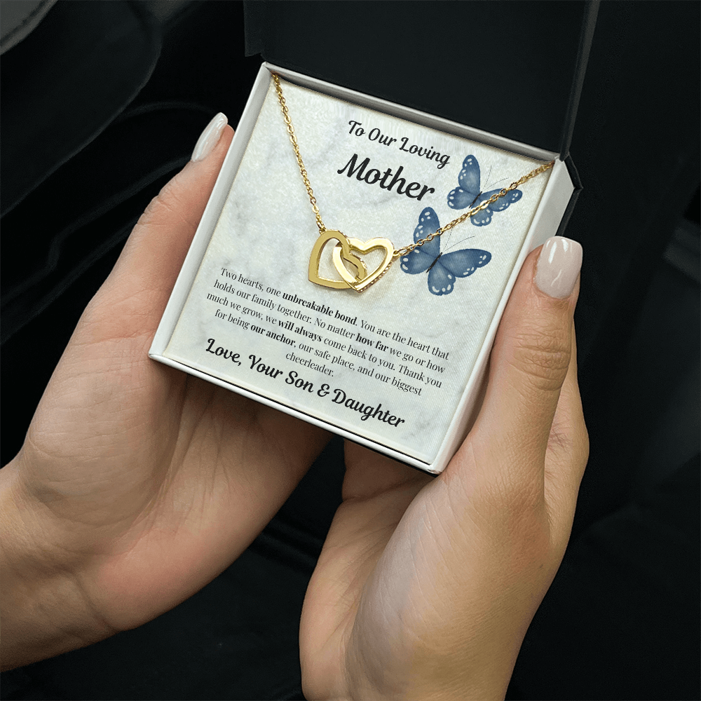 Hand holding 18K yellow gold-finish Interlocking Hearts Necklace in standard gift box