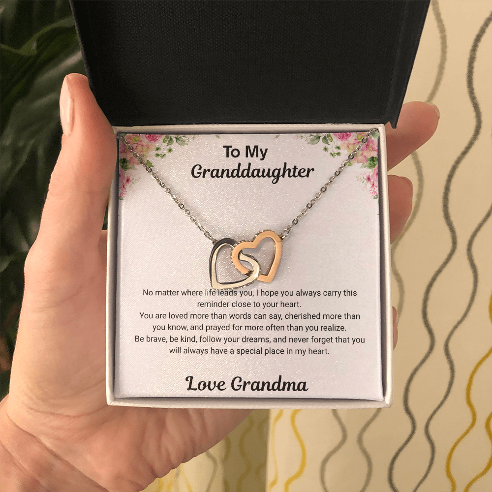 Hand holding 14k white gold-finish Interlocking Hearts Necklace in standard gift box with To My Granddaughter message card from Grandma