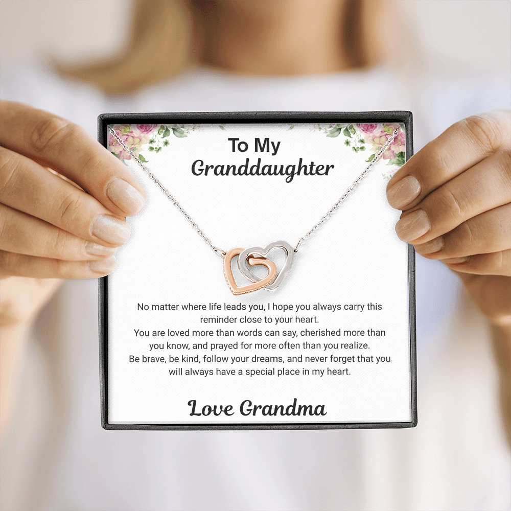 Hands holding 14k white gold-finish Interlocking Hearts Necklace with To My Granddaughter message card from Grandma