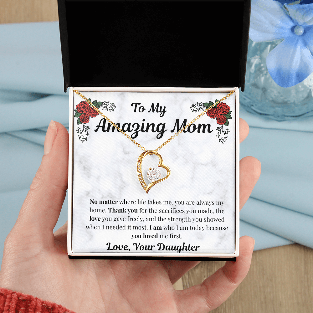 Hand holding 18k yellow gold-finish Forever Love Necklace in standard gift box
