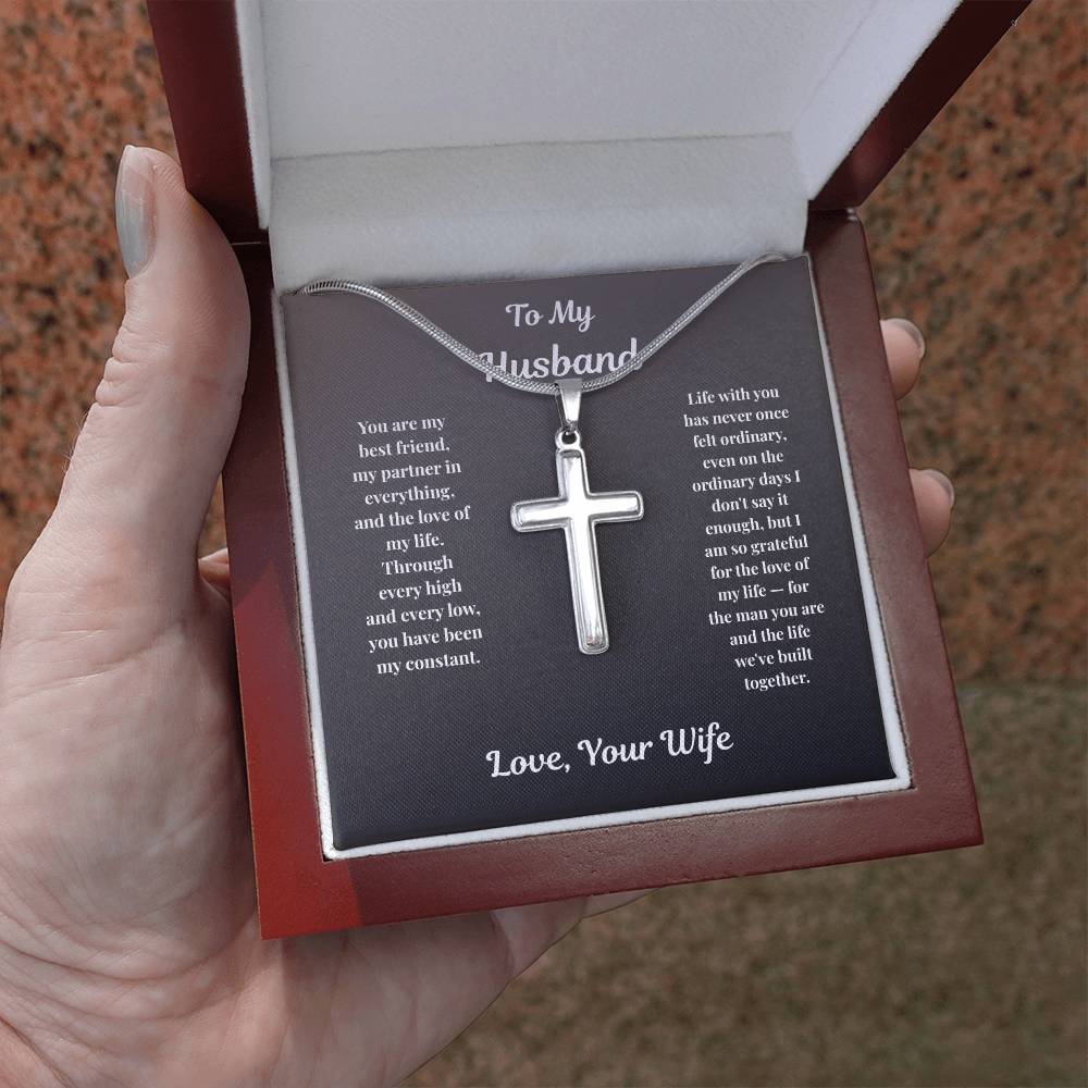 Hand holding stainless steel Cross Necklace in mahogany gift box